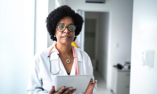 A doctor holding an iPad.